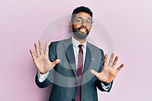 Handsome hispanic business man with beard wearing business suit and tie afraid and terrified with fear expression stop gesture