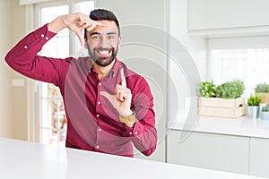 Handsome hispanic business man smiling making frame with hands and fingers with happy face
