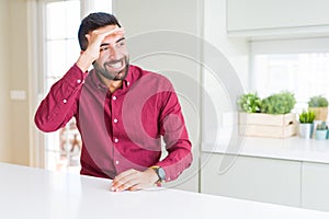 Handsome hispanic business man very happy and smiling looking far away with hand over head