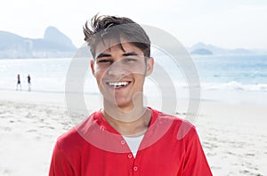 Handsome hispanic guy at beach looking at camera