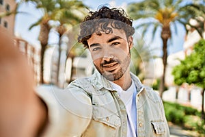 Handsome hispanic man with beard smiling happy outdoors on a sunny day