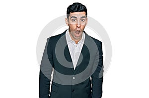 Handsome hispanic man wearing business clothes afraid and shocked with surprise and amazed expression, fear and excited face