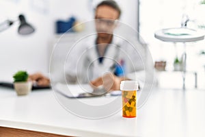 Handsome hispanic man working as doctor writing pills presciption at hospital clinic