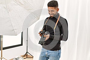 Handsome hispanic man working as professional photographer at photography studio