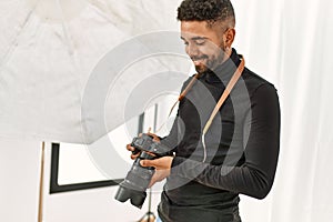 Handsome hispanic man working as professional photographer at photography studio