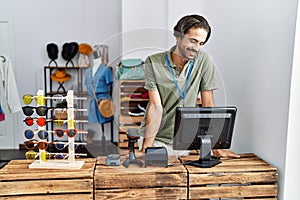 Handsome hispanic man working as shop assistance at retail shop