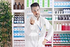 Handsome hispanic man working at pharmacy drugstore doing italian gesture with hand and fingers confident expression