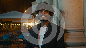 Handsome Indian Latino Arabian American man happy businessman smiling standing in evening city street outside jacket