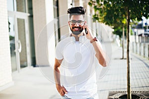 Handsome indian man cell phone call smile outdoor city street. Young attractive businessman casual blue shirt talking