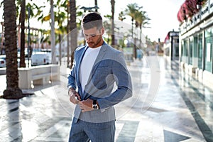 Handsome italian man walking on the city street wearing elegant fashionable suit