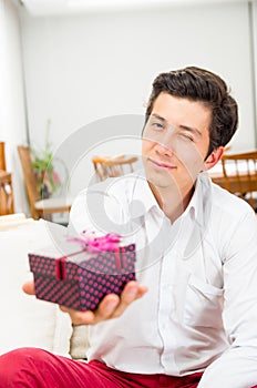 Handsome joyful young man holding Christmas