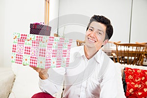 Handsome joyful young man holding Christmas