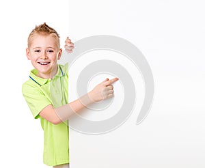 Handsome kid boy pointing to blank advertisement banner