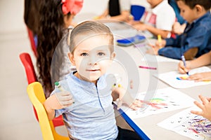 Cute little boy coloring with crayons