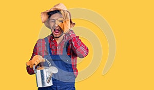 Handsome latin american young man holding vintage telephone smiling happy doing ok sign with hand on eye looking through fingers