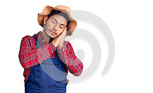 Handsome latin american young man weaing handyman uniform sleeping tired dreaming and posing with hands together while smiling