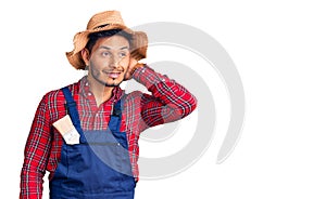 Handsome latin american young man weaing handyman uniform smiling confident touching hair with hand up gesture, posing attractive