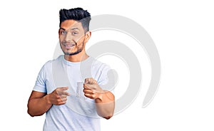 Handsome latin american young man wearing casual clothes pointing fingers to camera with happy and funny face