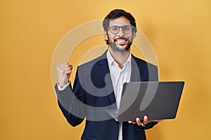 Handsome latin man working using computer laptop very happy and excited doing winner gesture with arms raised, smiling and