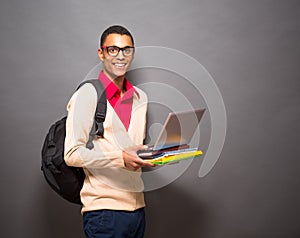 Handsome latin student with laptop computer in studio