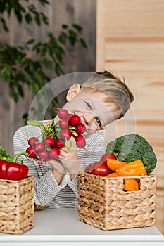Pěkný malý chlapec v jíst zelenina. vegetariánský. zdravý jídlo 