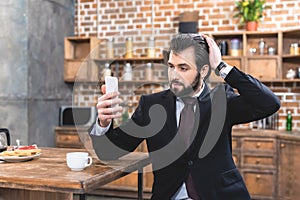 handsome loner businessman taking selfie with smartphone