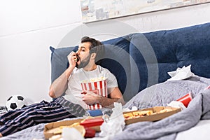 handsome loner eating popcorn and watching tv