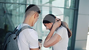 Handsome Lovely Couple standing near the Airport or Railway Station. They Pointing with her Finger in the Smartphone