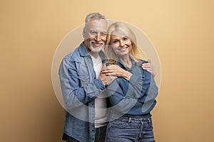 Handsome loving elderly man husband hugging his beautiful blonde wife