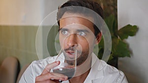 Handsome macho drinking wine glass at cafe interior closeup. Guy talking calmly