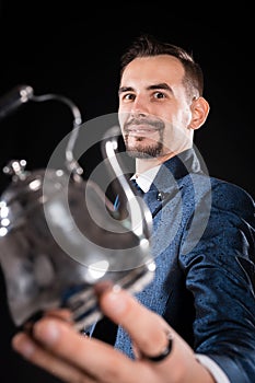 Handsome magician with a smile in a blue tailcoat