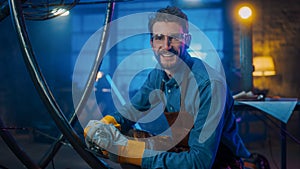 Handsome Male Artist Uses an Angle Grinder to Make Brutal Metal Sculpture in Studio. Cool Man Look