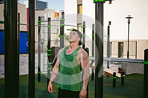 Handsome male bodybuilder athlete man doing crossfit workout in athletic facilities on sunny morning outdoors