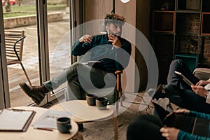 Handsome male business person gesticulating with his hands while explaining something to his colleague