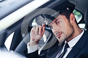 Handsome male chauffeur sitting in a car