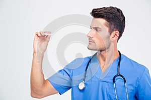 Handsome male doctor looking on thermometer