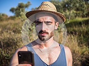 Handsome male farmer outdoor with cell phone