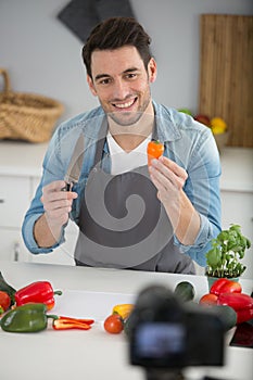 handsome male food blogger recording video in kitchen