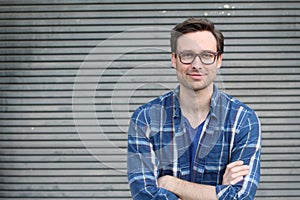 Handsome male with glasses portrait crossing his arms with copy space