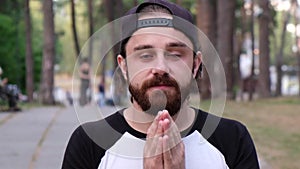 Handsome male with hands in namaste pose in city background