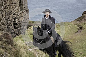 Handsome Male Horse Rider Regency 18th Century Poldark Costume with tin mine ruins and Atlantic ocean in background