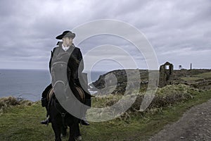 Handsome Male Horse Rider Regency 18th Century Poldark Costume with tin mine ruins and Atlantic ocean in background