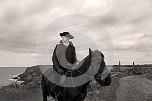 Handsome Male Horse Rider Regency 18th Century Poldark Costume with tin mine ruins and Atlantic ocean in background