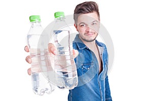 Handsome male model offering two bottles of cold water