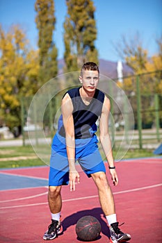 Handsome male playing basketball outdoor