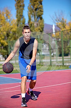 Handsome male playing basketball outdoor