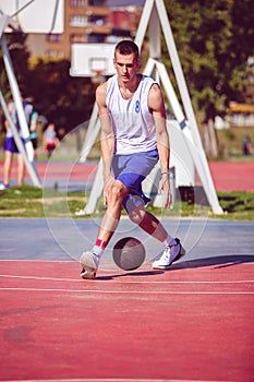 Handsome male playing basketball outdoor