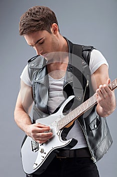 Handsome male rock musician is playing musical