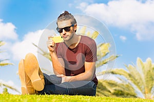 Handsome male sitting in the park using a cellphone