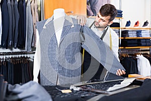 Handsome male tailor working in atelier